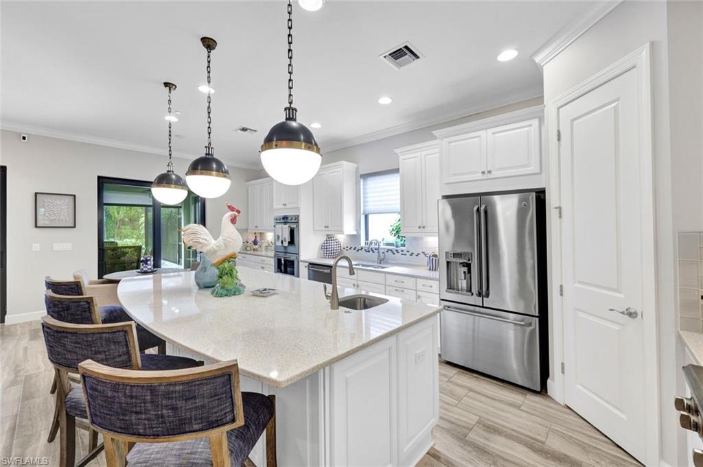 10163 Coconut Road Estero, FL 34135 - Photo 15 of 44 a kitchen with stainless steel appliances granite countertop a sink a refrigerator and a stove