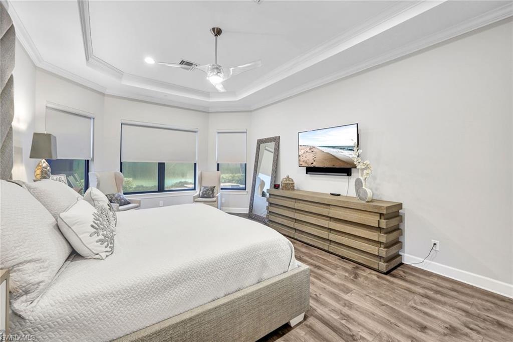 10163 Coconut Road Estero, FL 34135 - Photo 17 of 44 a spacious bedroom with a bed and a chandelier