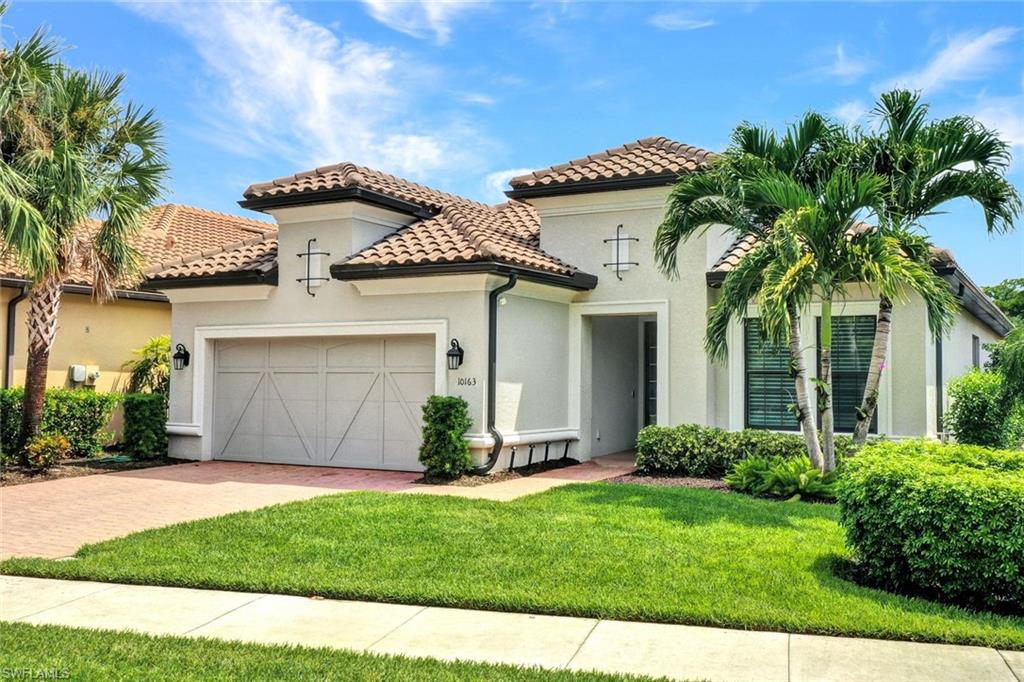 a view of a house with a yard and potted plants