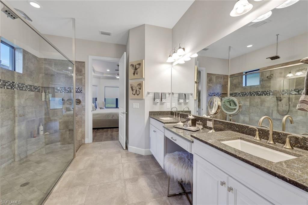 10163 Coconut Road Estero, FL 34135 - Photo 20 of 44 a spacious bathroom with a sink double vanity shower and a mirror