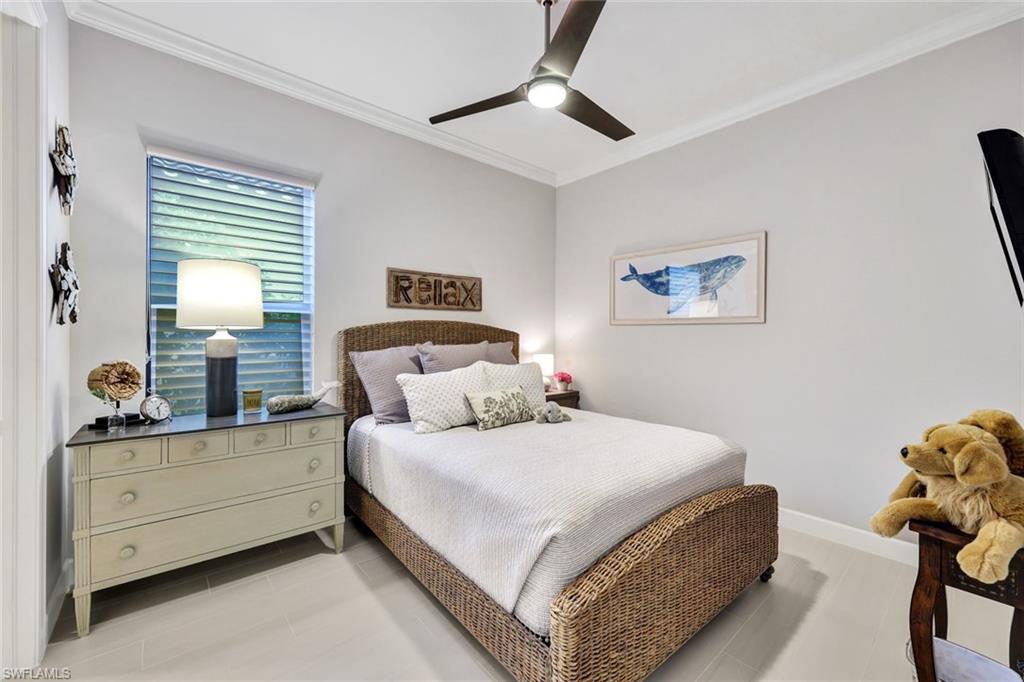 10163 Coconut Road Estero, FL 34135 - Photo 23 of 44 a bedroom with a bed and a chandelier