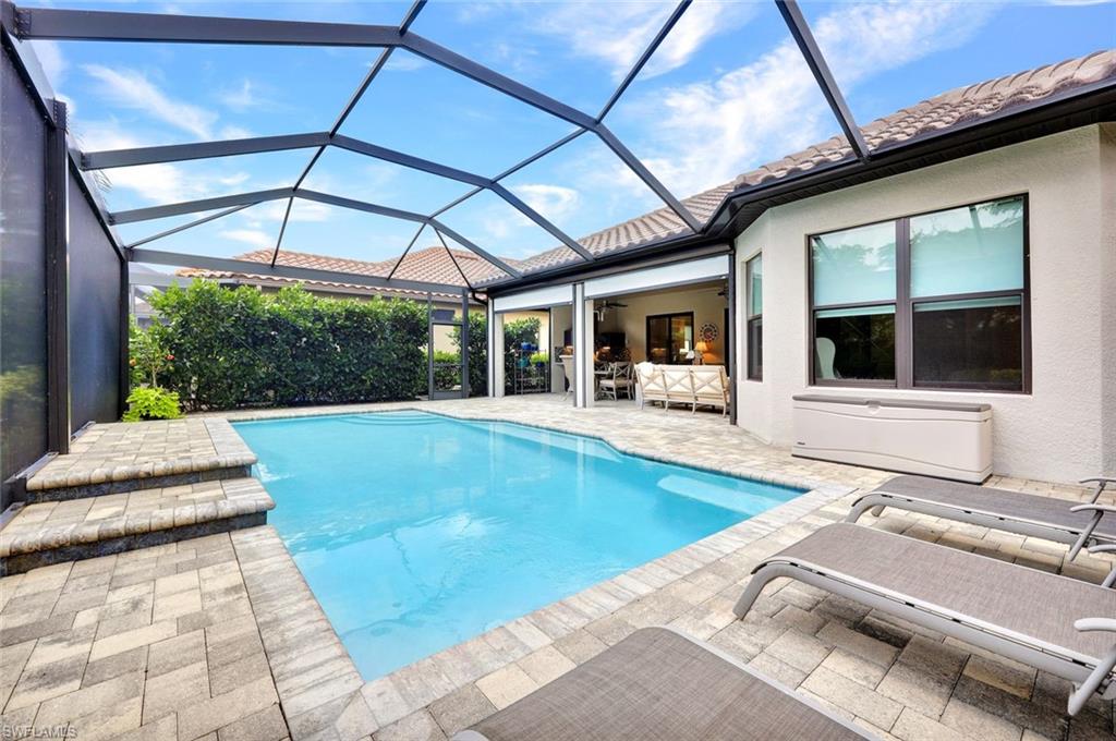 10163 Coconut Road Estero, FL 34135 - Photo 36 of 44 a view of a patio with a table and chairs under an umbrella