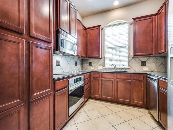 a kitchen with stainless steel appliances granite countertop a refrigerator and a sink