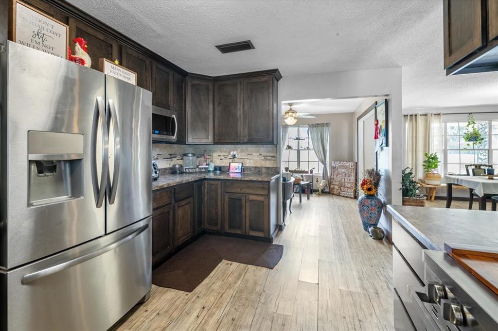 7422 County Road 231 Lake Butler, FL 32054 - Photo 15 of 57 a kitchen with stainless steel appliances a refrigerator a stove a sink dishwasher and cabinets with wooden floor