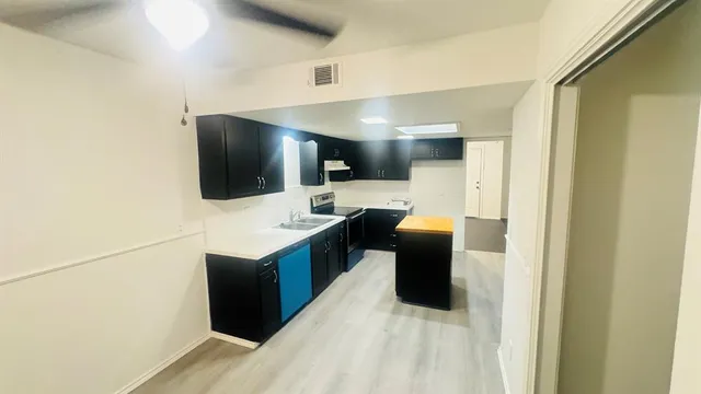 a kitchen with a refrigerator and a stove top oven