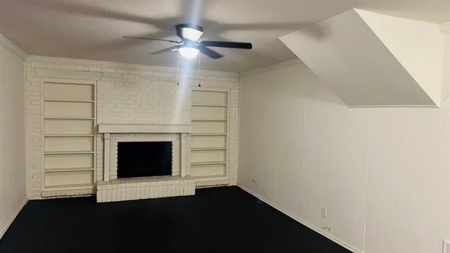 an empty room with windows and fireplace