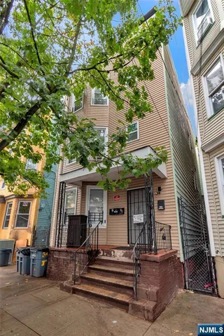a front view of a house with a tree