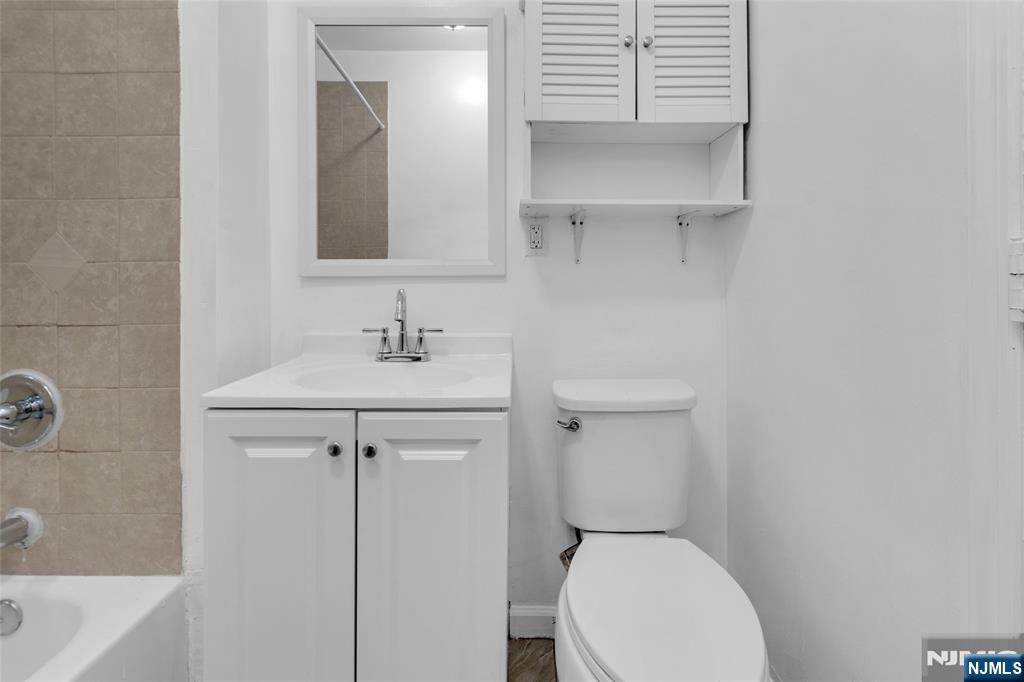 54 3rd Street, Unit 3 Newark, NJ 07107 - Photo 14 of 15 a bathroom with a toilet sink and mirror