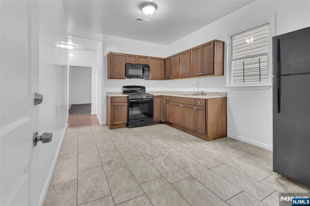 54 3rd Street, Unit 3 Newark, NJ 07107 - Photo 2 of 15 a large kitchen with cabinets and stainless steel appliances