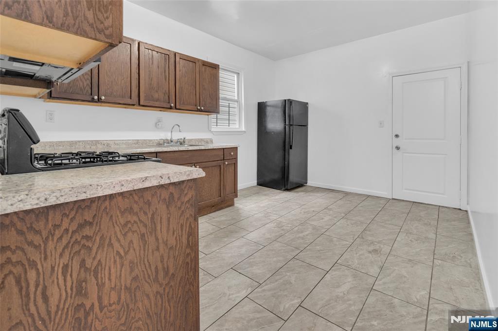 54 3rd Street, Unit 3 Newark, NJ 07107 - Photo 3 of 15 a kitchen with stainless steel appliances granite countertop a refrigerator a stove and a sink