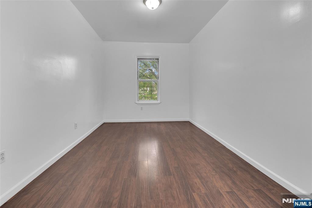 54 3rd Street, Unit 3 Newark, NJ 07107 - Photo 4 of 15 an empty room with wooden floor and windows