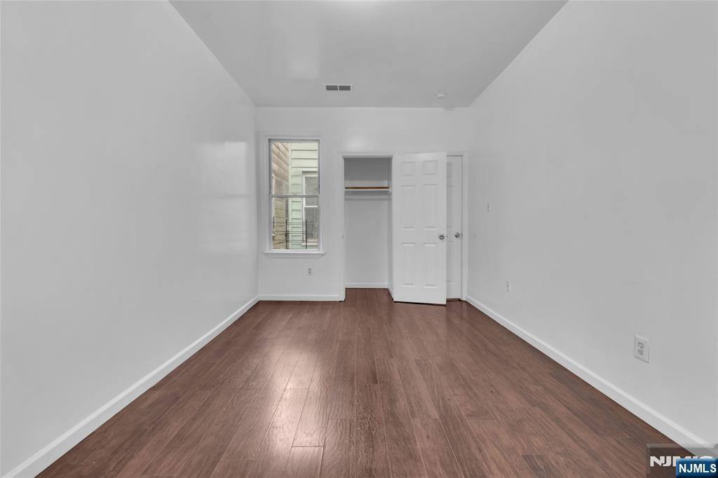54 3rd Street, Unit 3 Newark, NJ 07107 - Photo 5 of 15 an empty room with wooden floor and windows