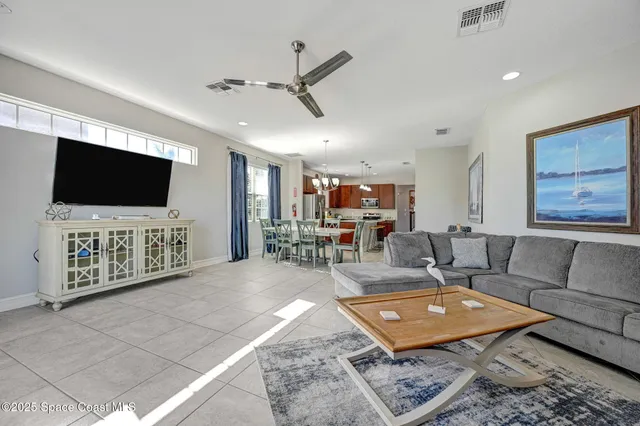 a spacious bedroom with a bed and a flat tv screen on dresser