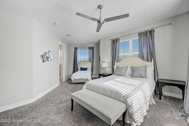 a bedroom with a bed a chandelier and a large window