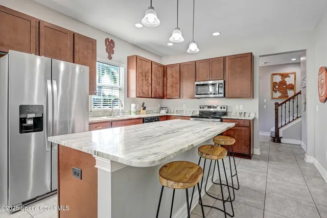 a kitchen with a sink a counter space and chairs
