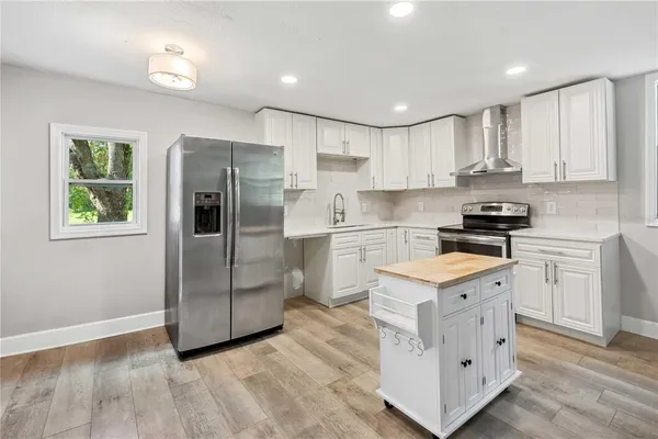 a kitchen with white cabinets and stainless steel appliances