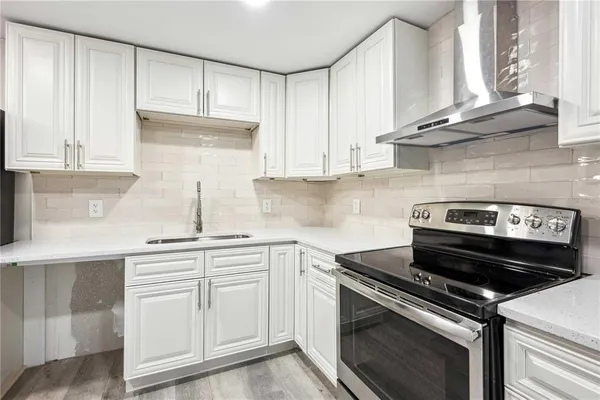 a kitchen with granite countertop white cabinets and stainless steel appliances