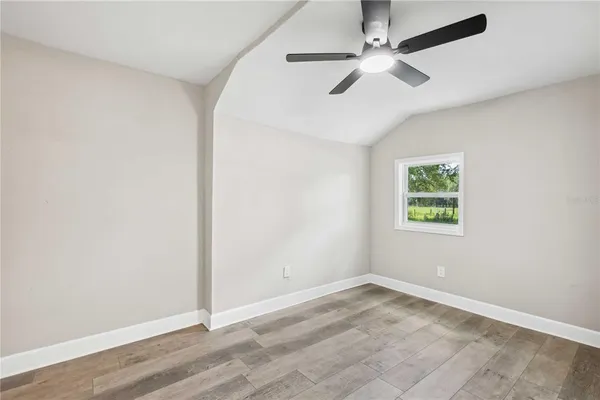 an empty room with a window and a fan