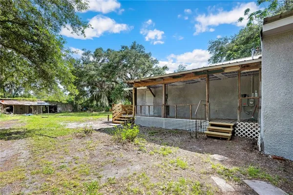 a backyard of a house with barbeque oven and table and chairs