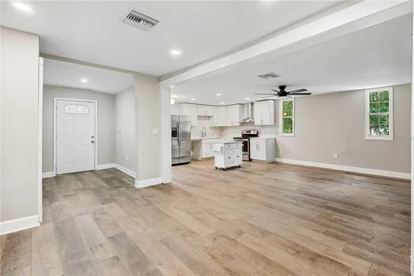 a view of empty room with wooden floor and window