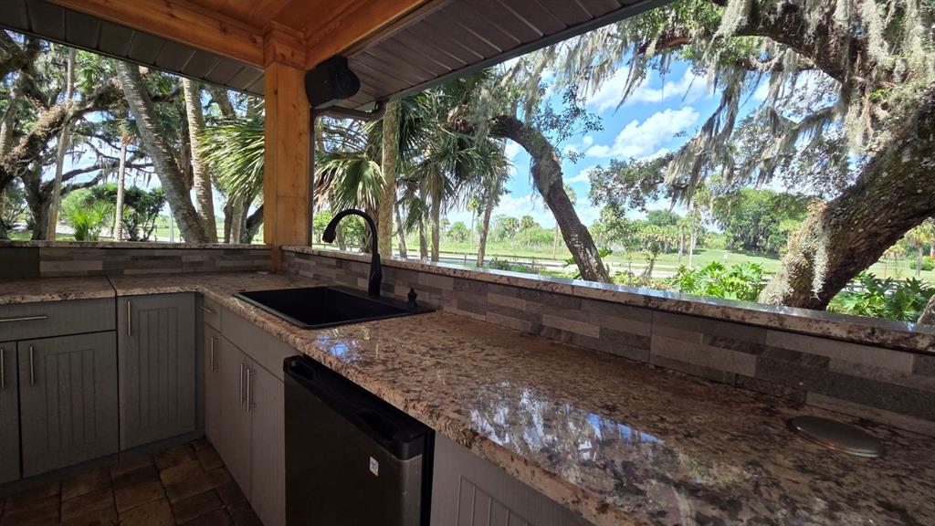 291 Bear Trail River Ranch, FL 33867 - Photo 14 of 23 a kitchen with a sink and large trees