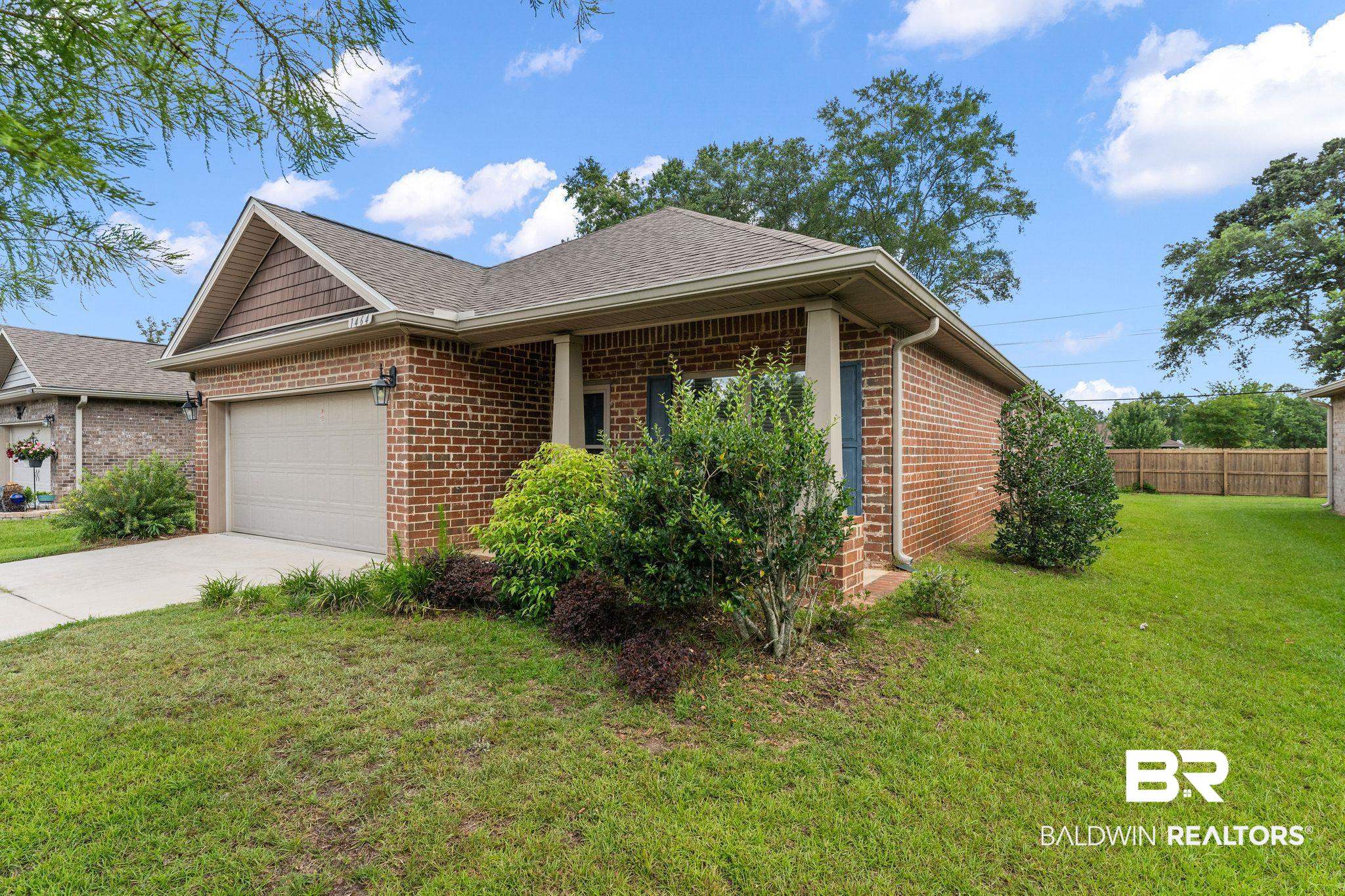 1464 Surrey Loop Foley, AL 36535 - Photo 3 of 24 View of side of property with brick siding, an attached garage, driveway, and a shingled roof