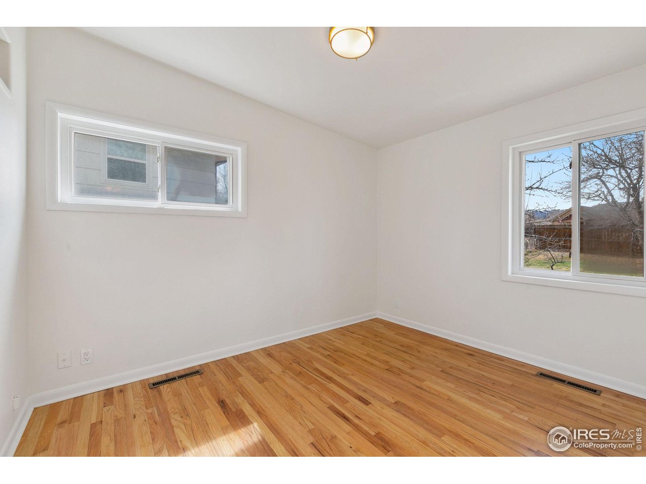 533 Crestmore Place Fort Collins, CO 80521 - Photo 14 of 19 a view of an empty room with wooden floor and a window