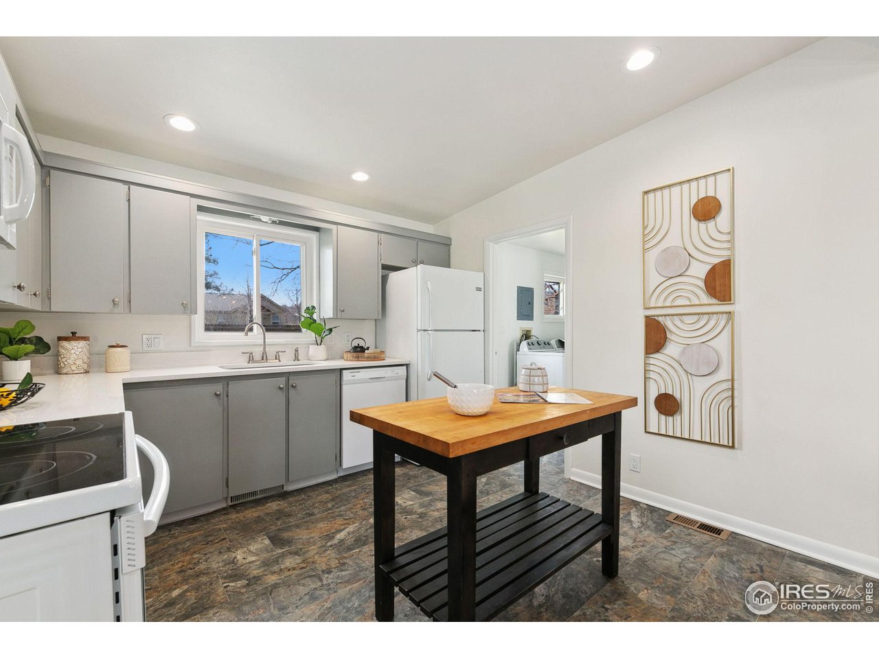 533 Crestmore Place Fort Collins, CO 80521 - Photo 7 of 19 a kitchen with stainless steel appliances kitchen island granite countertop a table chairs and a refrigerator