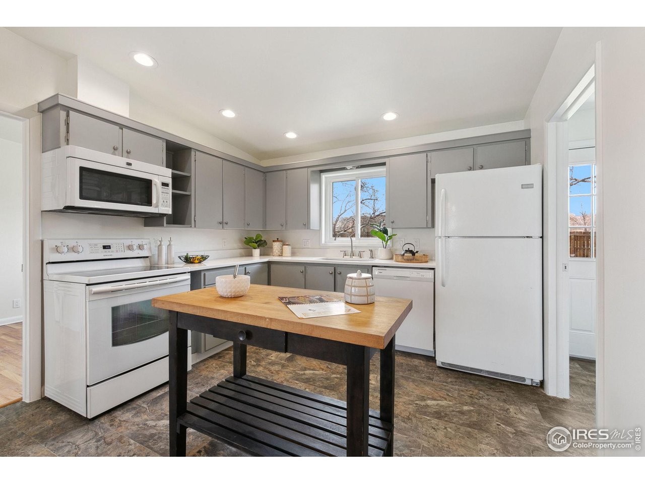 533 Crestmore Place Fort Collins, CO 80521 - Photo 8 of 19 a kitchen with a refrigerator a microwave a stove and cabinets