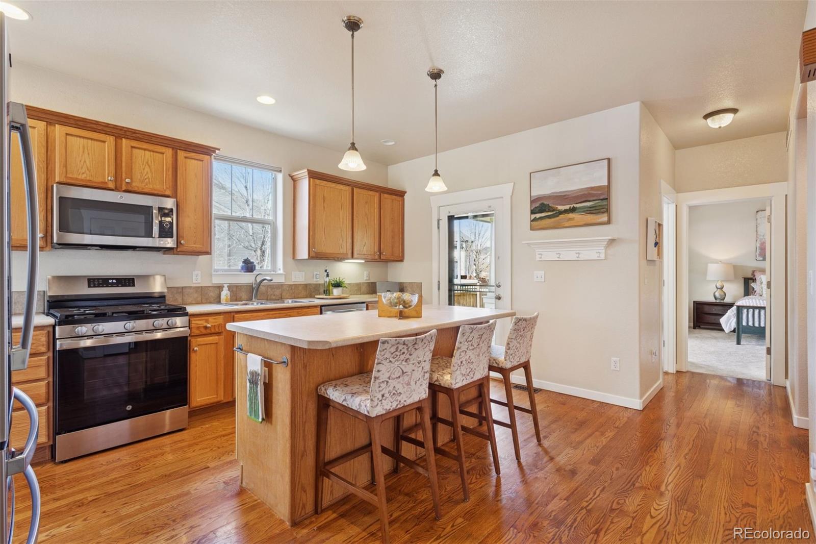 2882 Alton Street Denver, CO 80238 - Photo 8 of 42 a kitchen with stainless steel appliances granite countertop a stove a sink dishwasher a refrigerator and a dining table with wooden floor