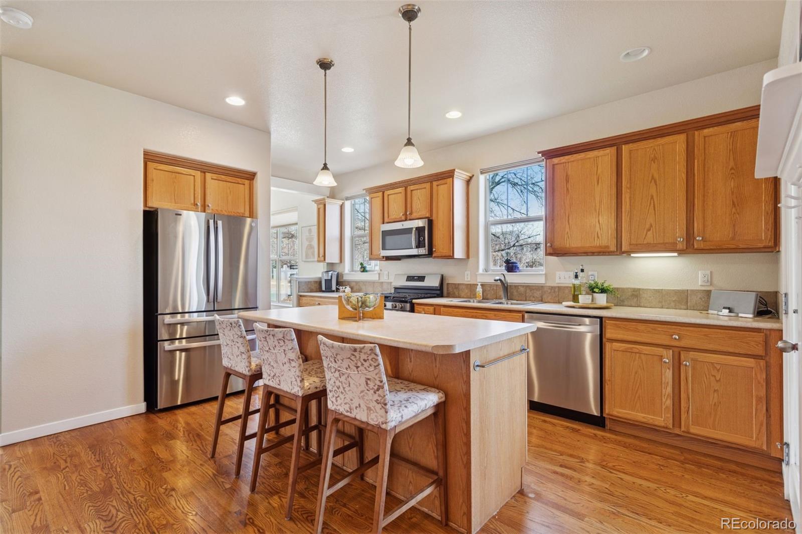 2882 Alton Street Denver, CO 80238 - Photo 9 of 42 a kitchen with stainless steel appliances granite countertop a table chairs refrigerator and sink