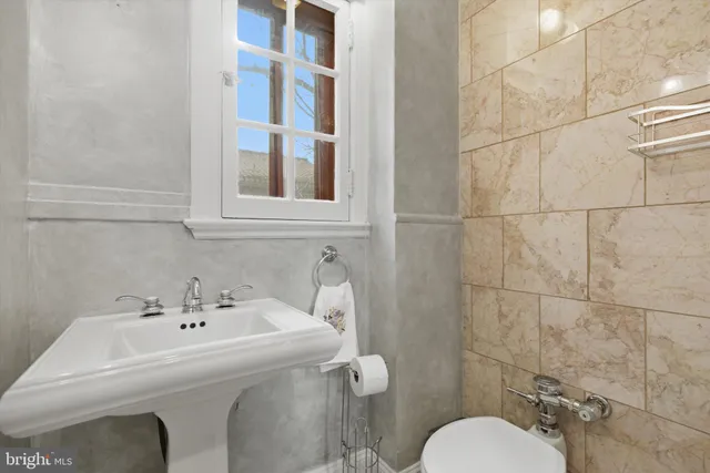 a bathroom with a sink toilet and a mirror