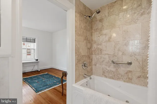 a bathroom with a granite countertop bathtub shower and sink
