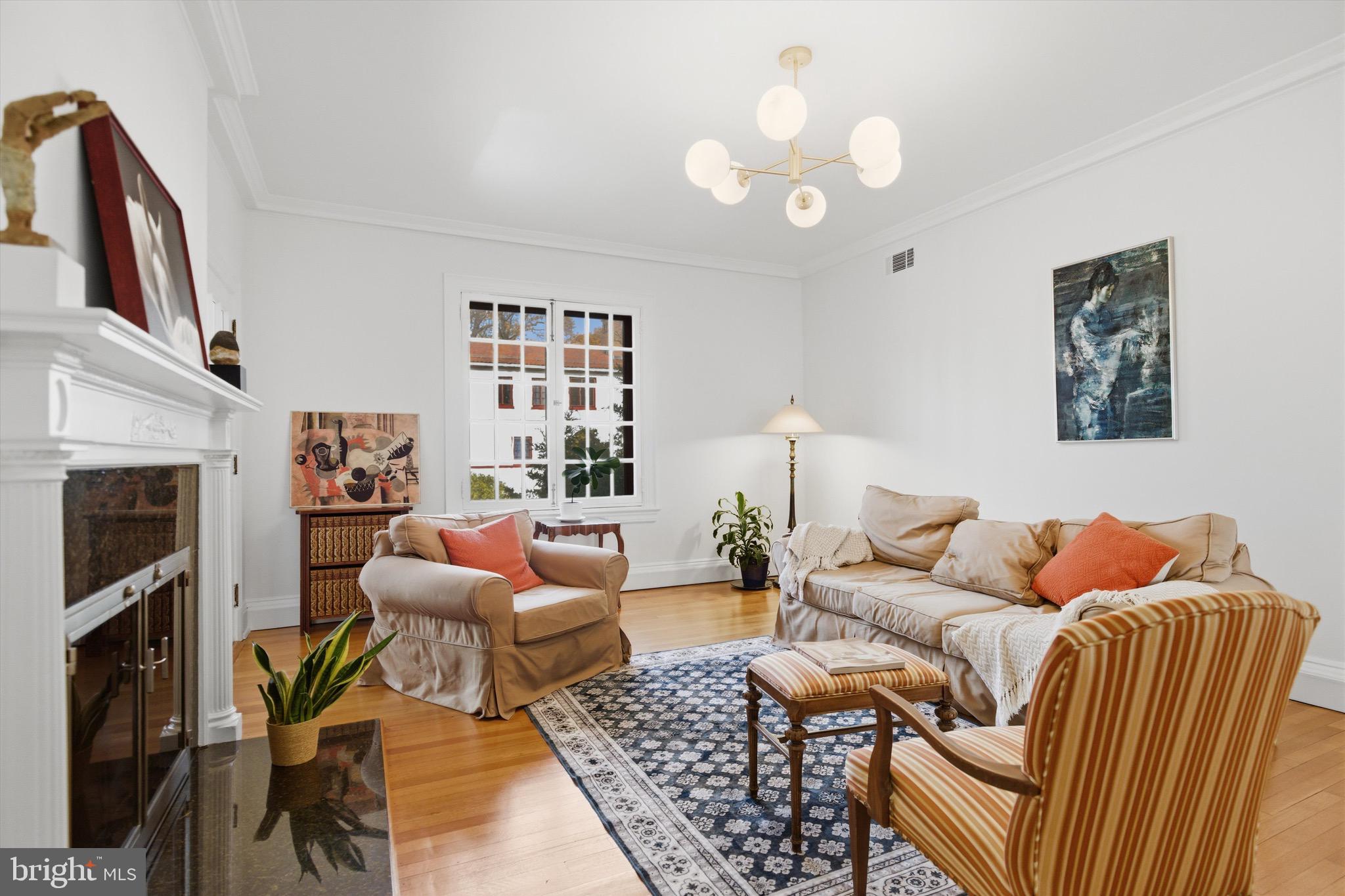 230 Stony Run Lane, Unit 4F Baltimore, MD 21210 - Photo 7 of 24 a living room with furniture a fireplace and a chandelier