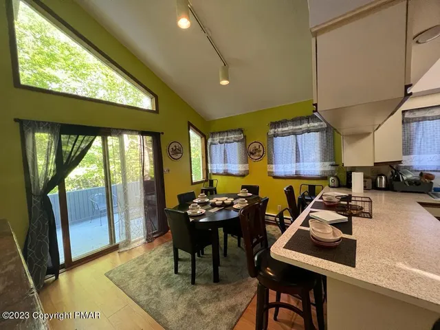a dining room with furniture and a floor to ceiling window
