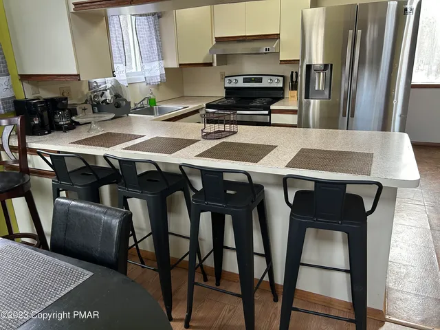 a kitchen with stainless steel appliances a stove a sink island and a refrigerator