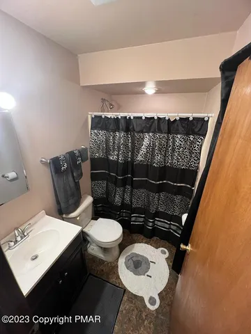 a bathroom with a toilet a sink and mirror