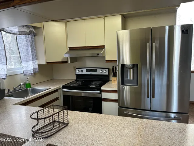a kitchen with a stove a refrigerator and a sink