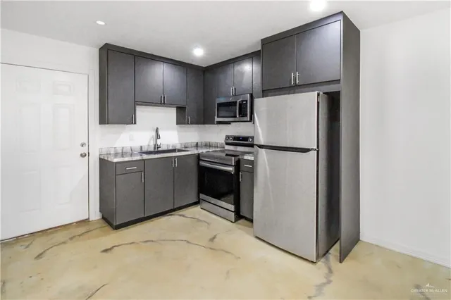 a kitchen with stainless steel appliances granite countertop a stove a refrigerator and a sink