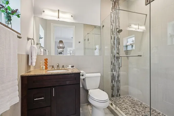 a bathroom with a sink toilet a mirror and shower