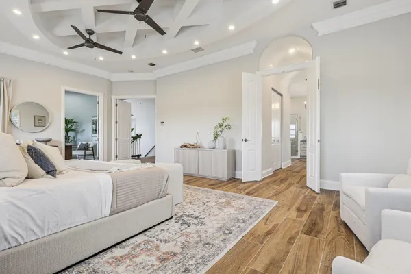 a spacious bedroom with a bed and ceiling fan