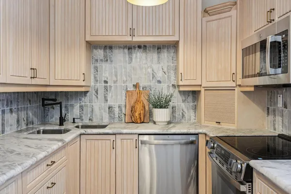 a kitchen with granite countertop a sink a stove and cabinets