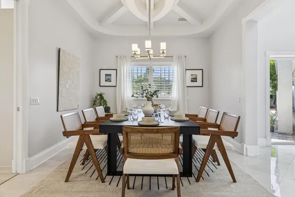 a view of a dining room with furniture a chandelier and wooden floor
