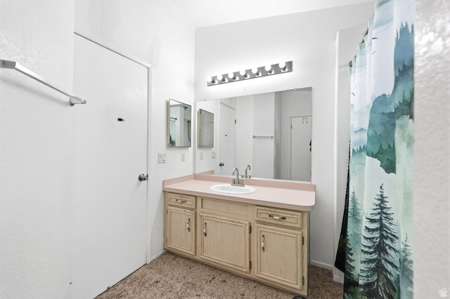 2491 Highway 89, Unit 614 Pleasant View, UT 84404 - Photo 15 of 27 Bathroom featuring a single vanity with an integrated sink, broad wall mirror, and overhead strip lighting