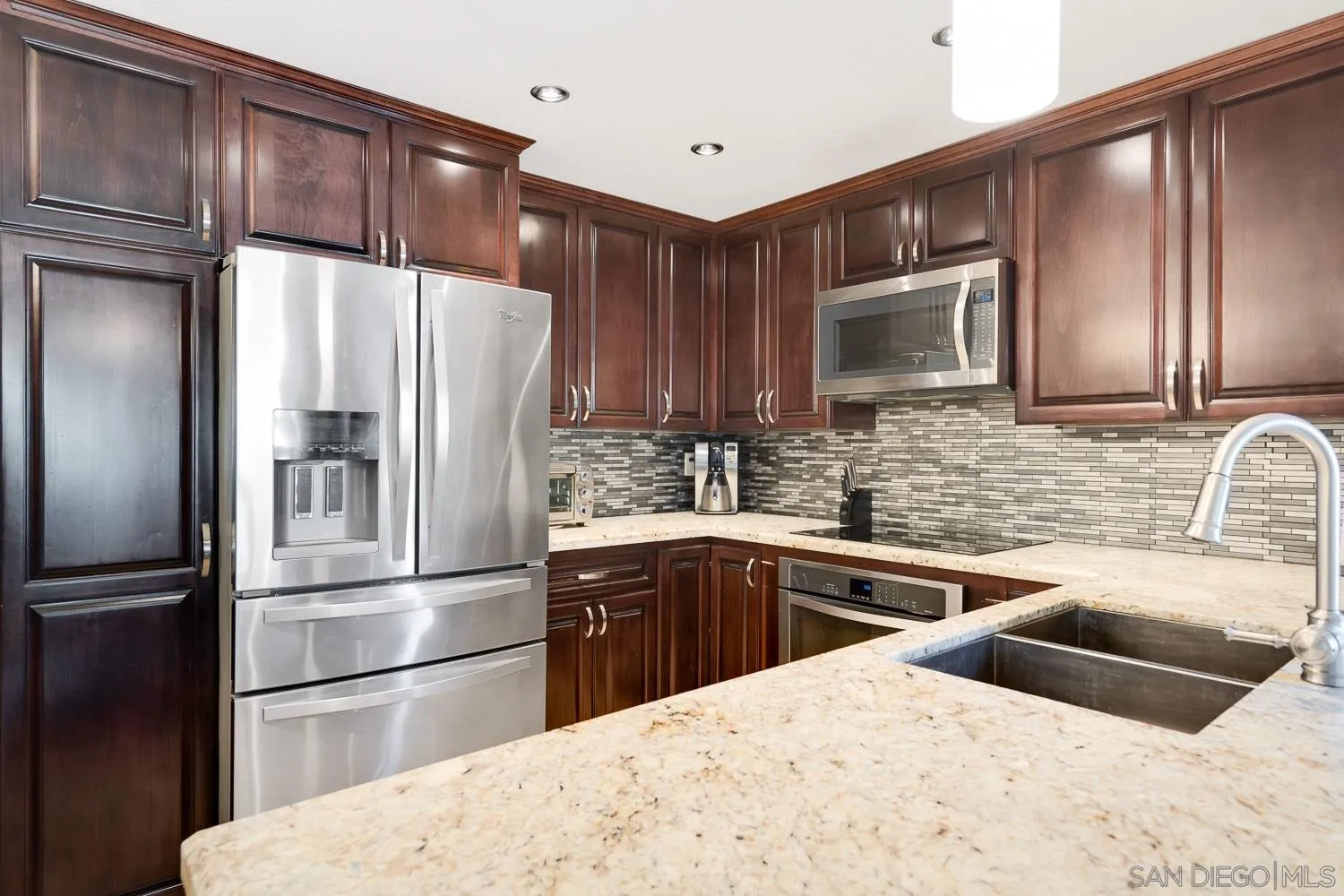 6052 Rancho Mission Road, Unit 408 San Diego, CA 92108 - Photo 5 of 36 a kitchen with stainless steel appliances kitchen island granite countertop a refrigerator microwave and sink