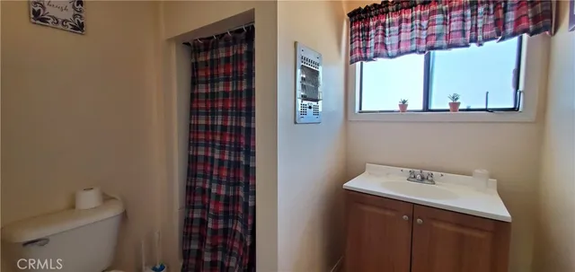 a bathroom with a sink a toilet and shower curtain