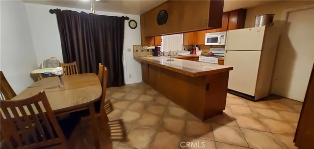 a kitchen with refrigerator and chairs