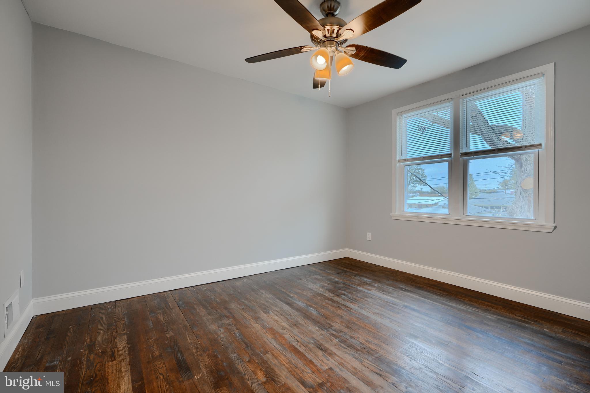 1632 Riverwood Road Baltimore, MD 21221 - Photo 11 of 32 a view of an empty room with a window and wooden floor