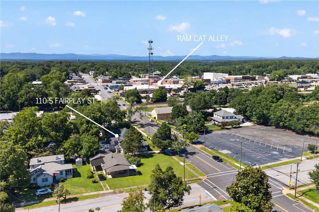 110 South Fairplay Street Seneca, SC 29678 - Photo 49 of 50 An aerial perspective reveals a charming town nestled amidst abundant greenery, with distant mountains providing a picturesque backdrop.