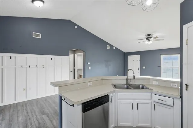 a kitchen with a sink cabinets and wooden floor
